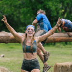 Participant showing peace sign with big smile as she finished the obstacle
