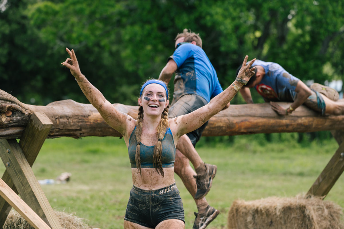 Participant showing peace sign with big smile as she finished the obstacle