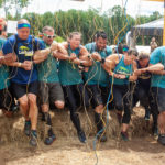 Participants linking arms while passing through Electroshock Therapy