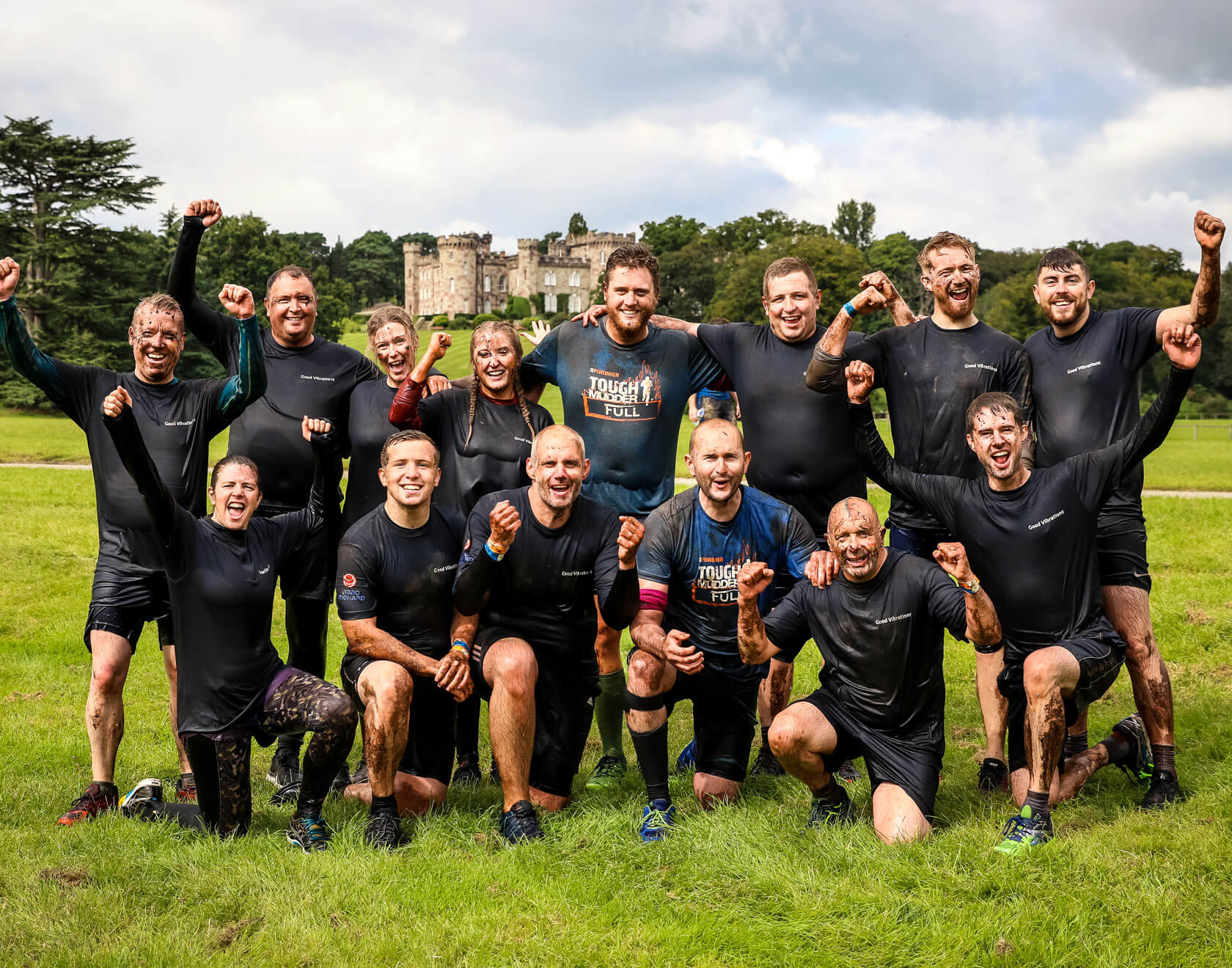 A group of participants posing for a picture with their hands in the air