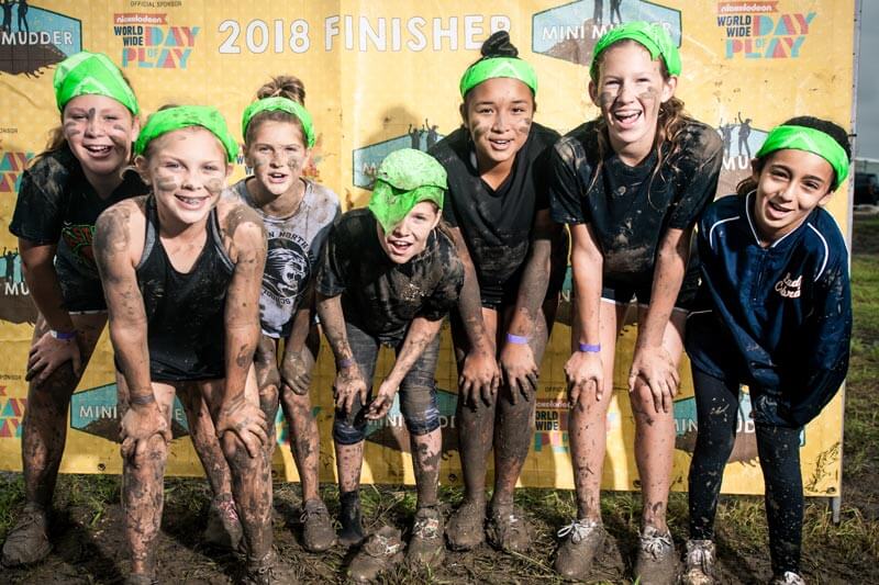Kid participants posing for a picture with mud in their bodies