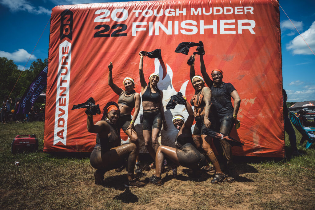 team in front Tough Mudder finisher wall 